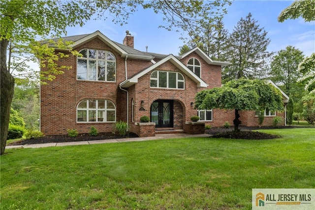 173 Old Beekman Rd, South Brunswick, NJ 08852 - view of front facade with french doors, a front lawn, a chimney, and brick siding