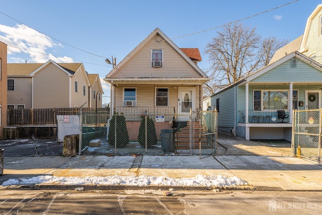 view of front of home with a fenced front yard, covered porch, and a gate