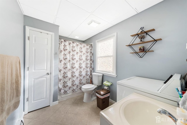 bathroom featuring toilet, tile patterned floors, independent washer and dryer, a paneled ceiling, and a sink