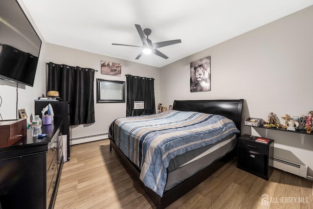 bedroom with a baseboard radiator, light wood-style floors, and a ceiling fan