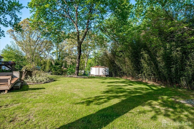 12 Sherry Rd, East Brunswick, NJ 08816 - view of green lawn featuring a storage shed, an outbuilding, and a wooden deck