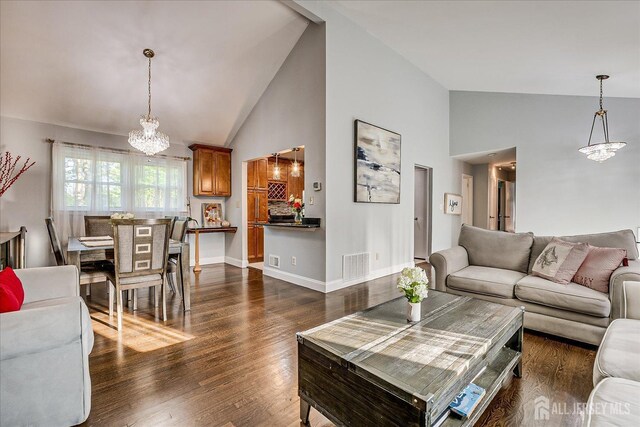 12 Sherry Rd, East Brunswick, NJ 08816 - living area featuring a chandelier, high vaulted ceiling, dark wood finished floors, and baseboards