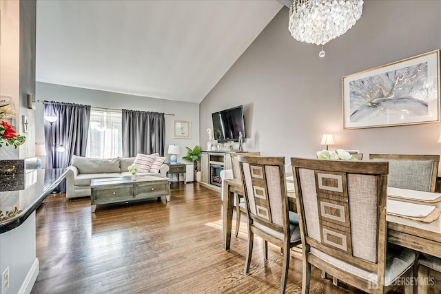 living area with wood finished floors, high vaulted ceiling, and a chandelier