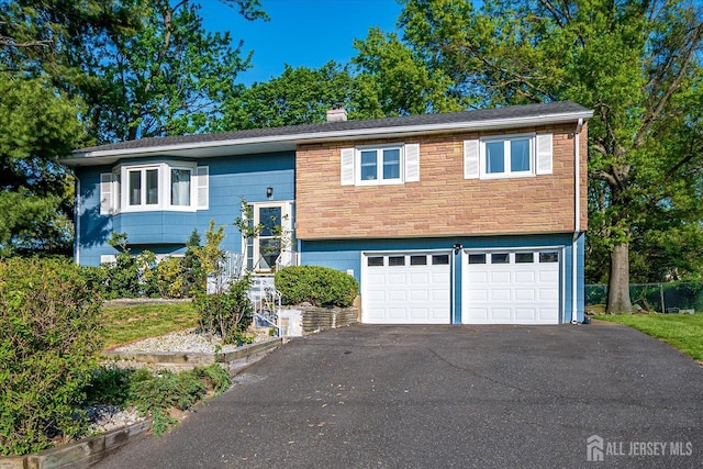 12 Sherry Rd, East Brunswick, NJ 08816 - raised ranch featuring an attached garage, driveway, and a chimney