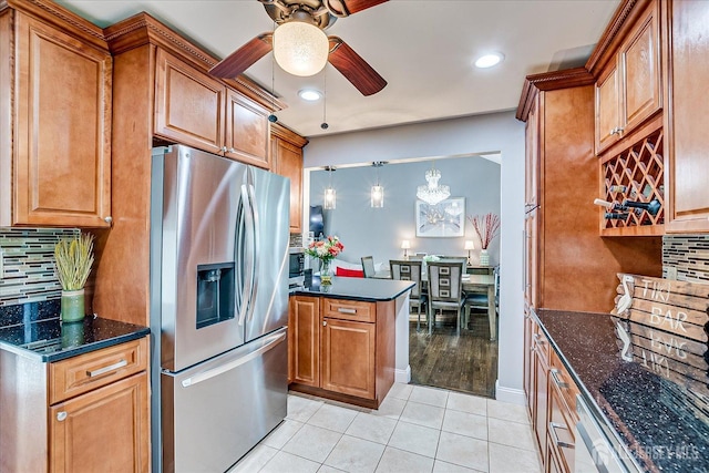 kitchen with stainless steel refrigerator with ice dispenser, ceiling fan, light tile patterned floors, brown cabinetry, and backsplash