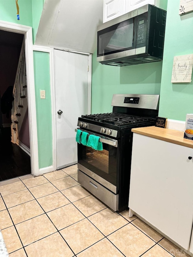 kitchen featuring stainless steel appliances, light countertops, white cabinetry, and light tile patterned flooring