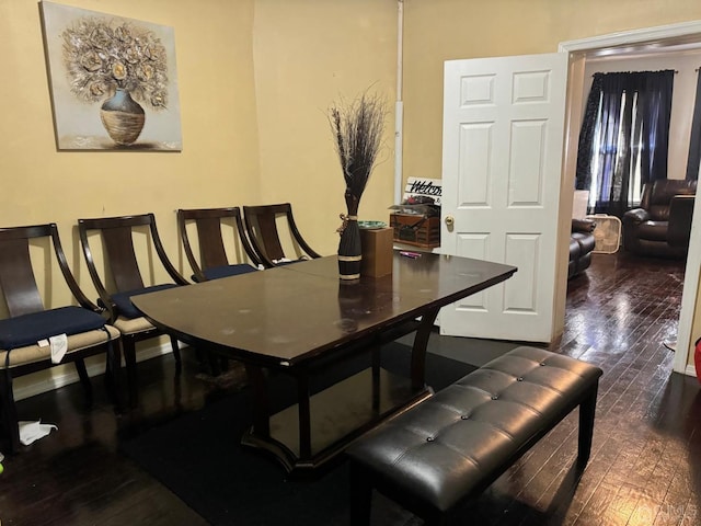 dining space featuring dark wood finished floors and baseboards