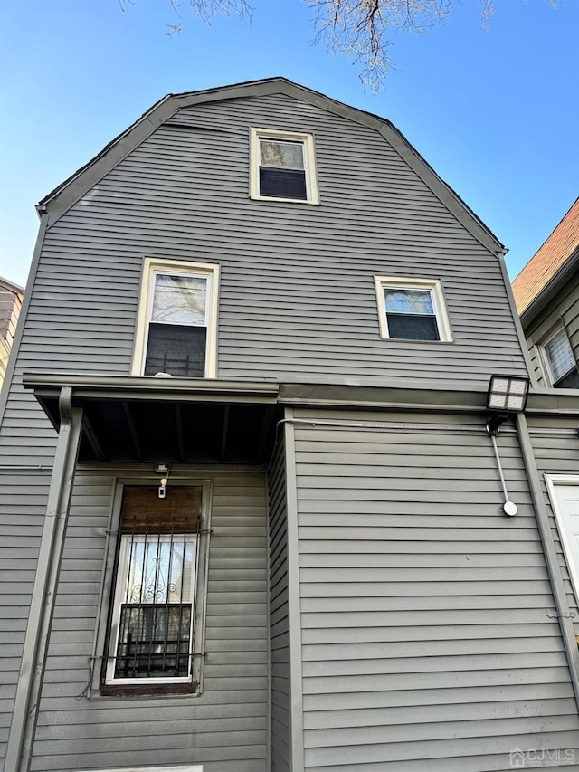 view of side of property featuring a gambrel roof