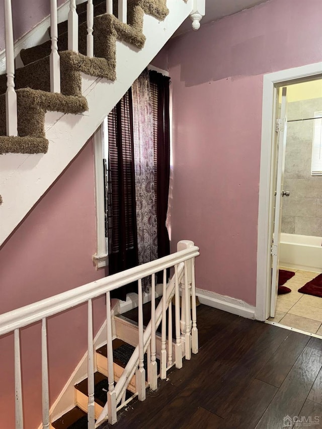 stairway with baseboards and wood finished floors