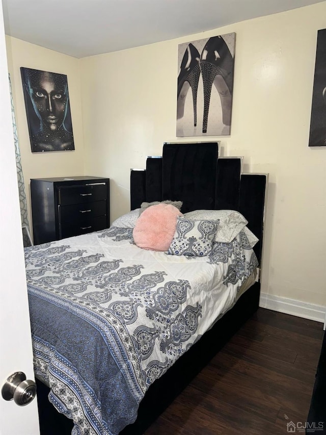 bedroom featuring dark wood-style floors and baseboards