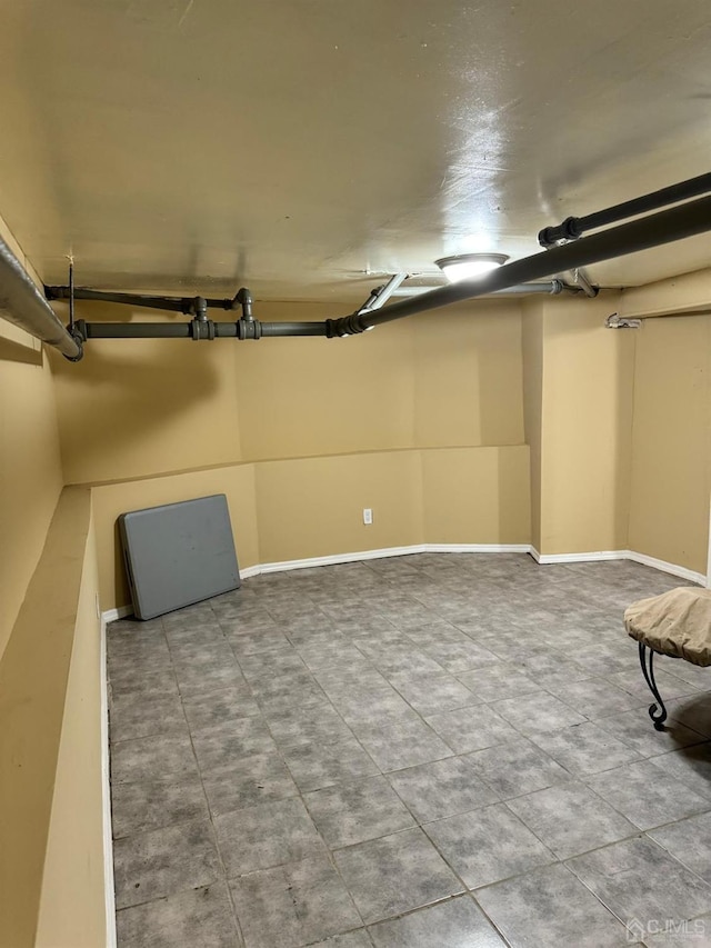 basement featuring a garage and baseboards