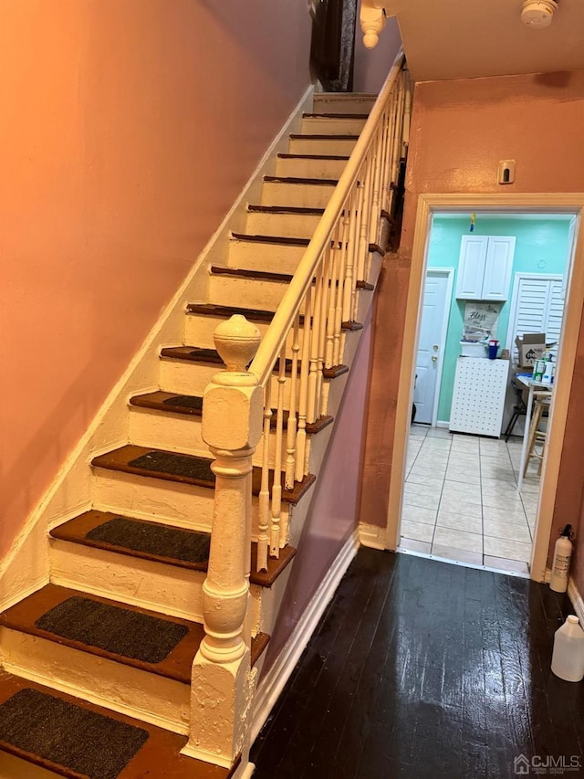 stairs with wood finished floors and baseboards