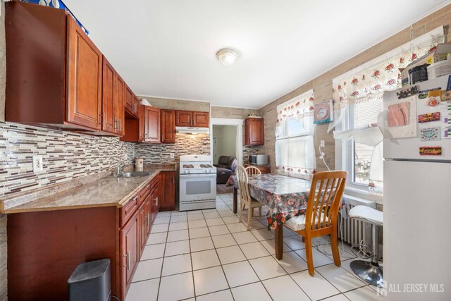 kitchen with sink, backsplash, white appliances, and light tile patterned floors