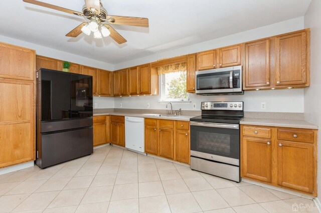 kitchen featuring ceiling fan, sink, light tile patterned floors, and stainless steel appliances