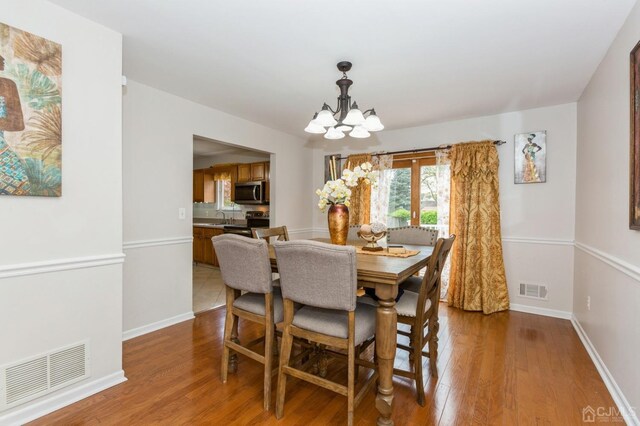 dining room featuring hardwood / wood-style flooring and a notable chandelier