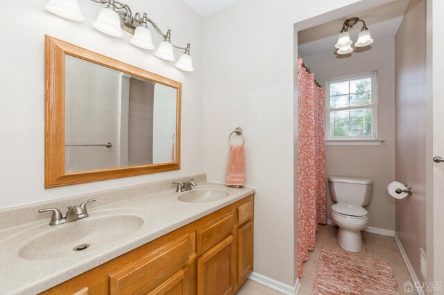 bathroom featuring tile patterned flooring, vanity, and toilet