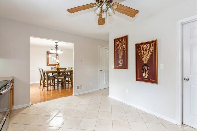 interior space with ceiling fan with notable chandelier