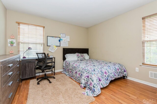 bedroom featuring light hardwood / wood-style flooring and multiple windows