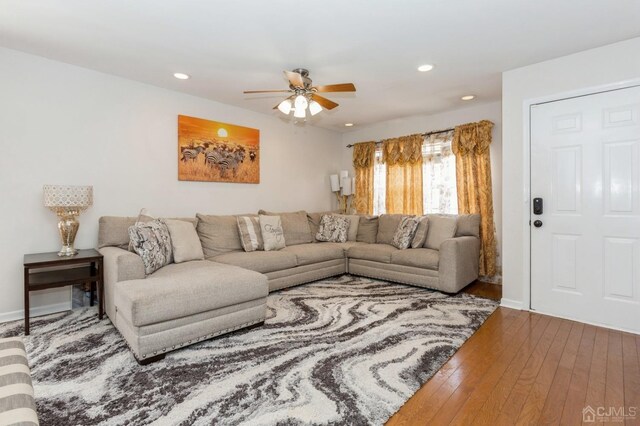 living room featuring hardwood / wood-style floors and ceiling fan