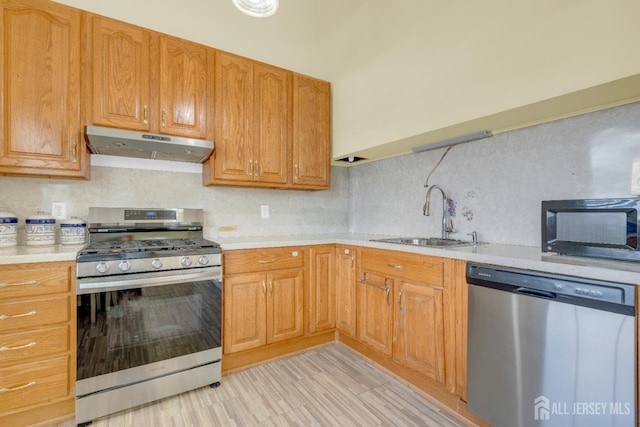 186 Tyler Ave, Iselin, NJ 08830 - kitchen with appliances with stainless steel finishes, under cabinet range hood, light countertops, backsplash, and light wood-style flooring