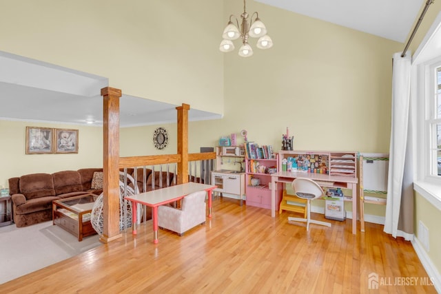 186 Tyler Ave, Iselin, NJ 08830 - recreation room featuring wood finished floors, a chandelier, a towering ceiling, and decorative columns