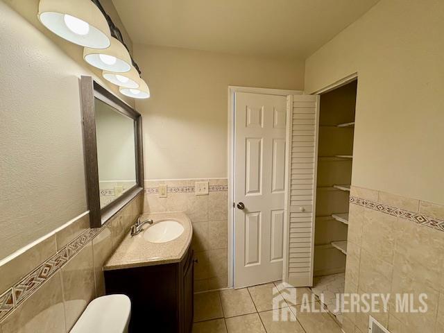 21 Rice Run, East Brunswick, NJ 08816 - bathroom featuring tile walls, tile patterned flooring, vanity, and wainscoting