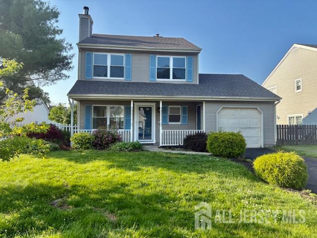 21 Rice Run, East Brunswick, NJ 08816 - view of front of house with a chimney, an attached garage, a porch, and asphalt driveway