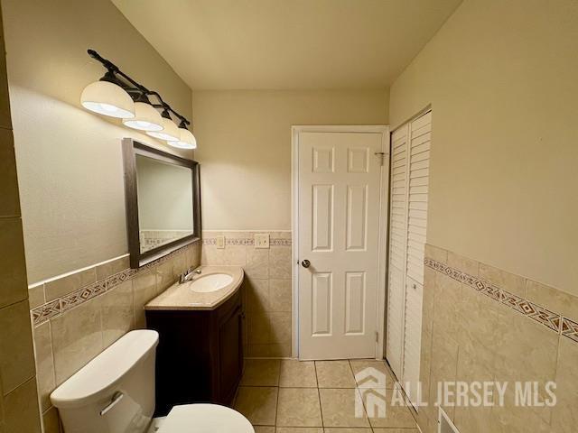 21 Rice Run, East Brunswick, NJ 08816 - bathroom with tile walls, wainscoting, vanity, tile patterned floors, and toilet
