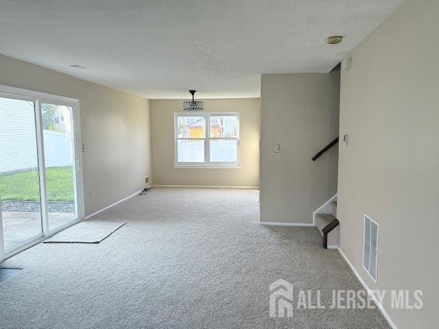 21 Rice Run, East Brunswick, NJ 08816 - carpeted spare room with healthy amount of natural light, stairway, and baseboards