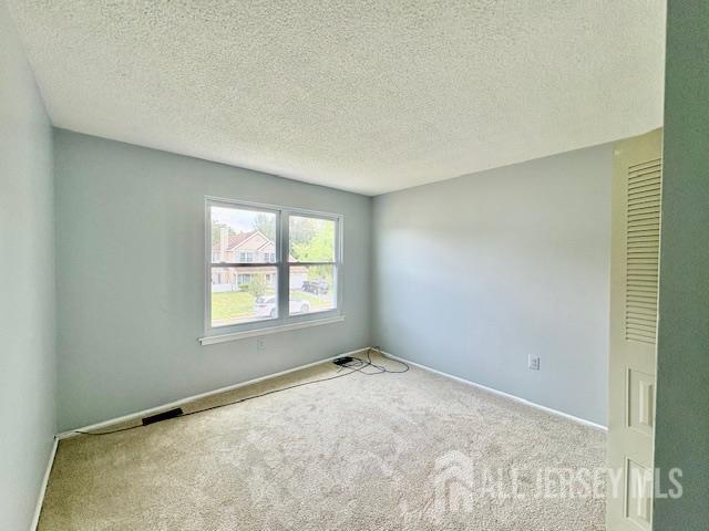 21 Rice Run, East Brunswick, NJ 08816 - carpeted spare room featuring a textured ceiling and baseboards