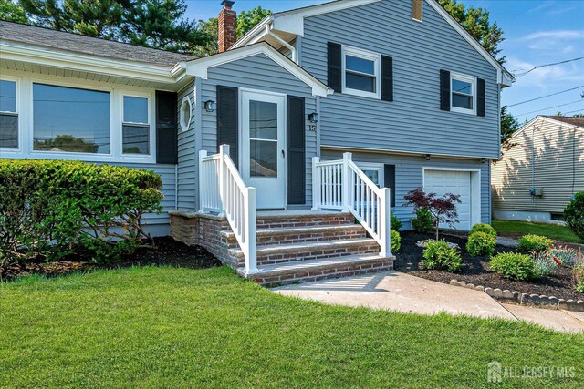 15 Crassas St, Old Bridge, NJ 08879 - view of front facade with a chimney, a front lawn, and an attached garage