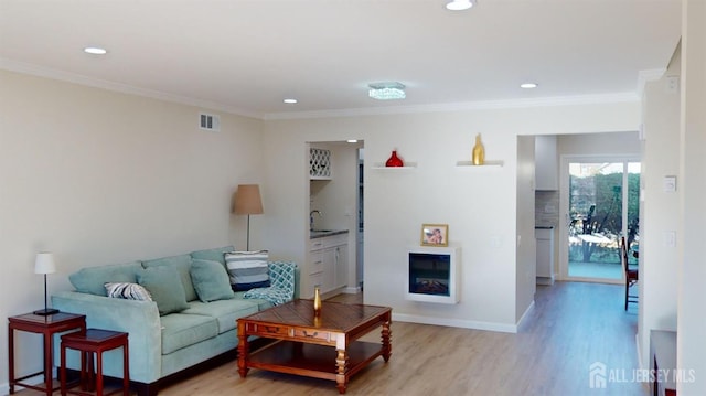 414-D Andover Dr, Monroe, NJ 08831 - living area featuring light wood finished floors, crown molding, recessed lighting, a glass covered fireplace, and baseboards