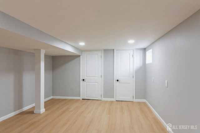 basement featuring light wood-style floors, baseboards, and recessed lighting