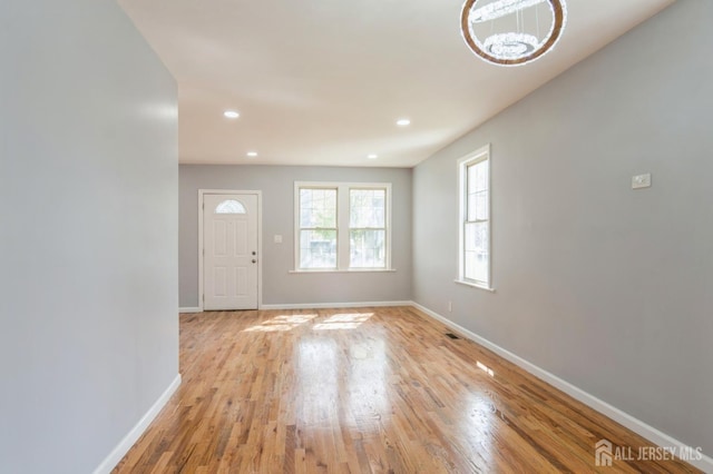 entryway featuring recessed lighting, light wood-style floors, baseboards, and a notable chandelier