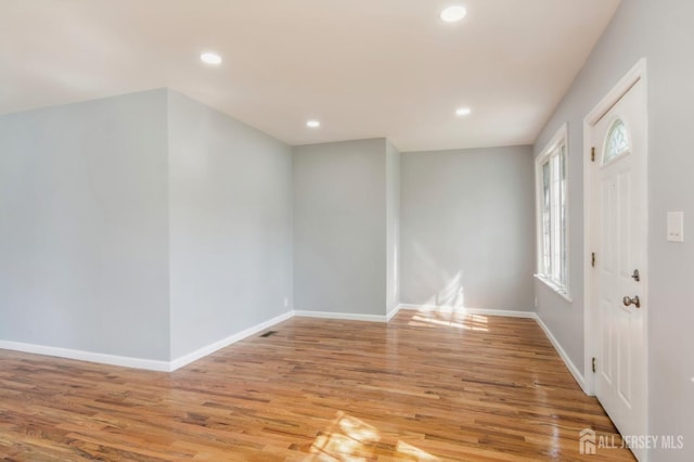 foyer with light wood finished floors, baseboards, and recessed lighting