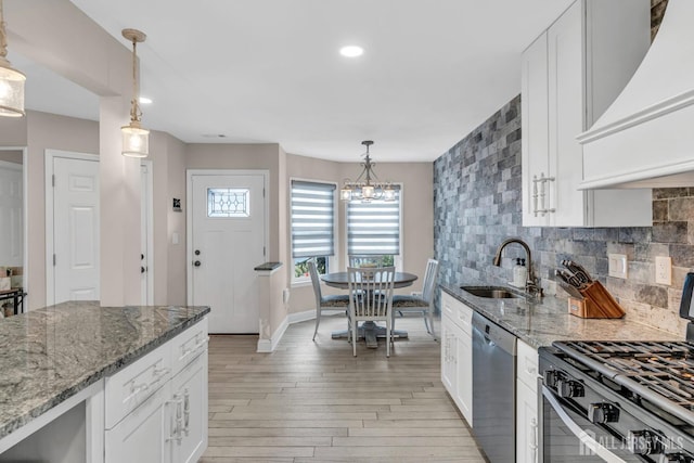 103 Rumford Way, Manalapan, NJ 07726 - kitchen with stainless steel dishwasher, range with gas stovetop, a sink, premium range hood, and light wood finished floors