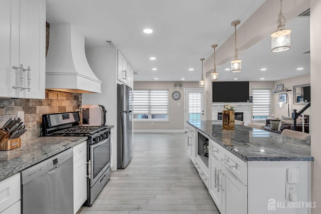 103 Rumford Way, Manalapan, NJ 07726 - kitchen with appliances with stainless steel finishes, premium range hood, light wood finished floors, decorative backsplash, and baseboards