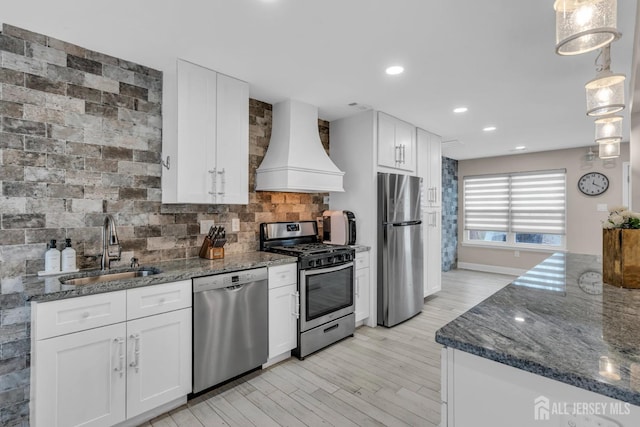 103 Rumford Way, Manalapan, NJ 07726 - kitchen with appliances with stainless steel finishes, premium range hood, a sink, tasteful backsplash, and white cabinets
