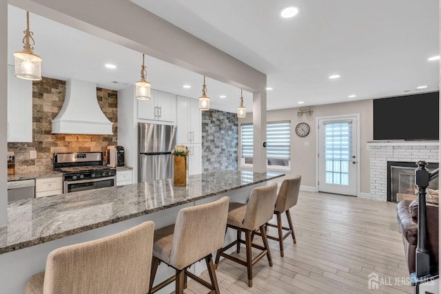 103 Rumford Way, Manalapan, NJ 07726 - kitchen with stainless steel appliances, premium range hood, backsplash, a kitchen breakfast bar, and recessed lighting