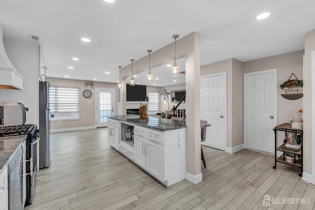 103 Rumford Way, Manalapan, NJ 07726 - kitchen featuring gas range oven, light wood-style flooring, freestanding refrigerator, dark stone countertops, and white cabinets