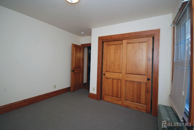 unfurnished bedroom featuring carpet floors and radiator heating unit