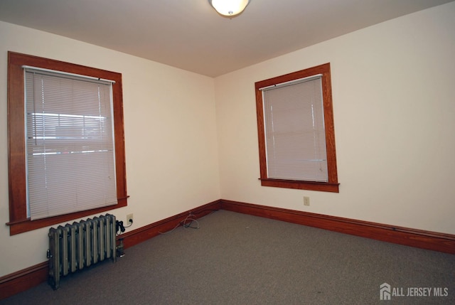 empty room with radiator heating unit and carpet flooring