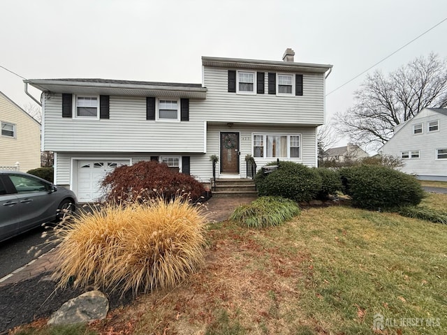 view of front of property featuring a front yard and a garage