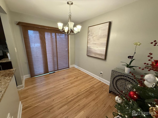 unfurnished dining area with light hardwood / wood-style floors and an inviting chandelier