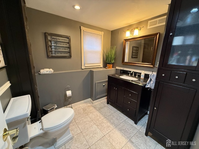 bathroom featuring tile patterned flooring, vanity, and toilet