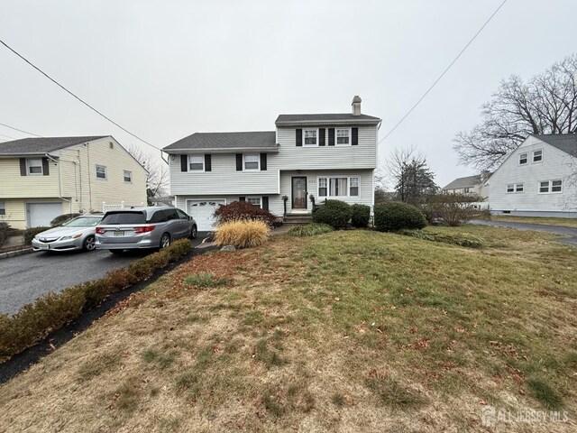 view of front of home featuring a garage and a front lawn