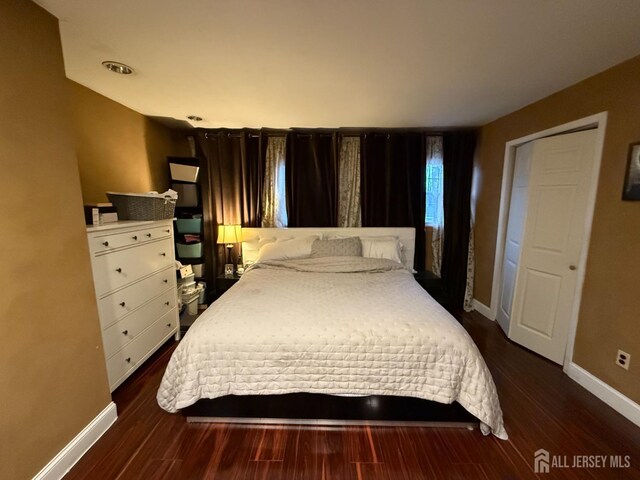 bedroom with dark hardwood / wood-style flooring