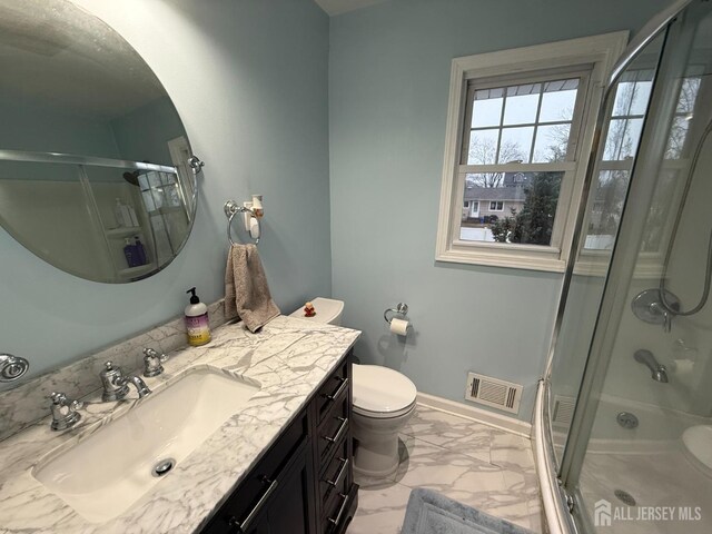 bathroom with vanity, an enclosed shower, and toilet