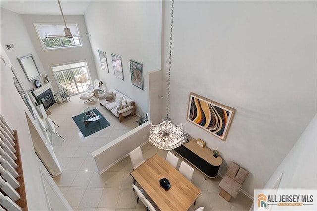 6503 Schindler Dr, South Brunswick, NJ 08852 - tiled living area featuring a towering ceiling, a ceiling fan, and a glass covered fireplace