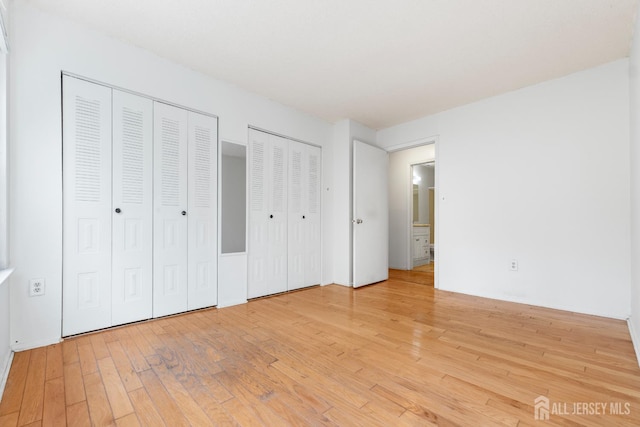 255 Hampshire Ct, Piscataway, NJ 08854 - unfurnished bedroom featuring two closets and light wood finished floors
